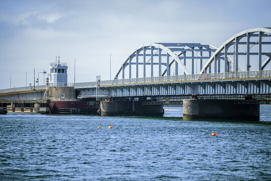 Historic Oddesund Bridge (Oddesundbroen) in Denmark. Beautiful bascule bridge with steel arches and control tower crossing the Limfjord sea strait under a bright sky on a summer day.