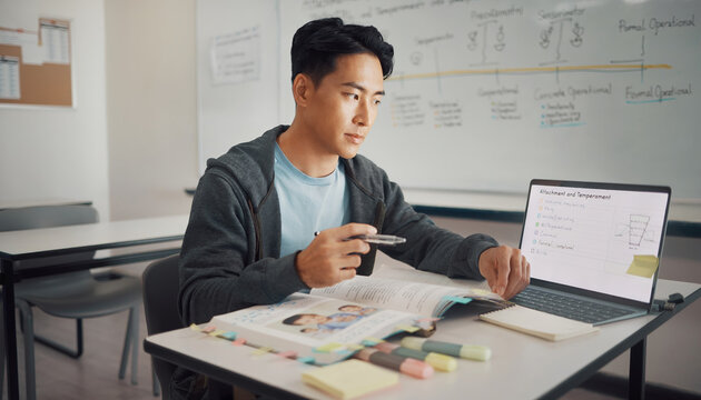 Young man studying at a desk with a laptop and books.