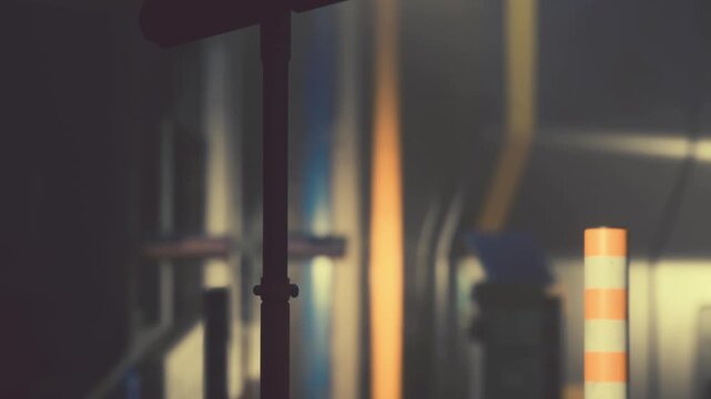 Equipment is arranged in a dark indoor space. Lights shine on walls and surfaces. People are preparing for a creative project. The atmosphere shows work in progress.