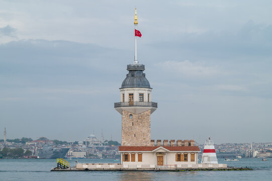 Stone tower on water with city behind