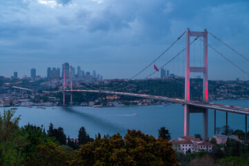 Naklejka premium Night view of illuminated Bosphorus Bridge with city lights in background