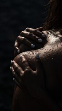 Erotic and Seductive Woman Covering Bare Breasts with Hands on dark background with copy space