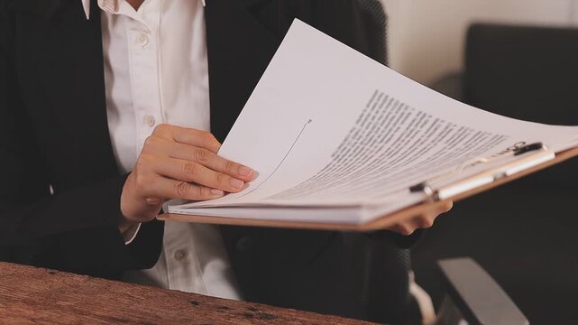 Legal advisor is explaining the offense under the law in the book at office.