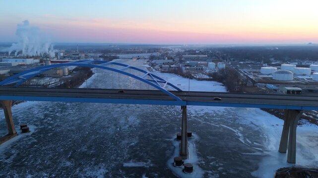 Right to Left bridge Aerial of tall Bridge in Green Bay towering over the Fox River in February.  Evening hours and beautiful light on the horizon.