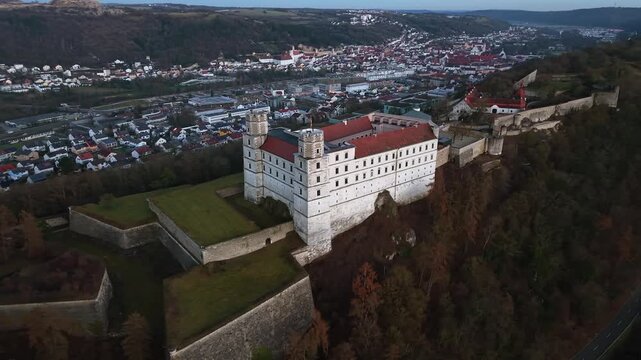 Cinematic aerial view of Willibaldsburg Castle in Eichstaett, Bavaria, Germany. Medieval fortress complex on hilltop, overlooking the Altmuehltal valley, old town, and surrounding natural landscape.