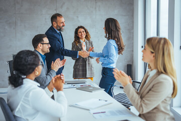 Fototapeta na wymiar Business Team Meeting Celebrating New Hire With Handshake and Applause in Modern Office