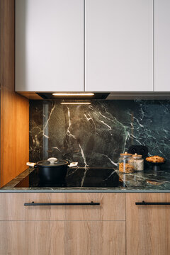 Induction hob in modern kitchen with cooking items on the countertop