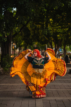 A sturdy Latina-Gypsy woman dancing traditional dances in the streets of M&eacute;rida, Yucat&aacute;n, Mexico; the famous Paseo Montejo is visible in the background.
