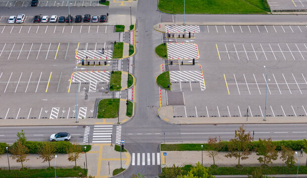 Aerial view of a modern parking lot with marked spaces, pedestrian crossings, and green landscaping in Vilnius, Vilnius County, Lithuania.