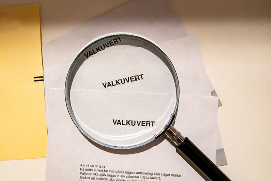 Stockholm, Sweden  A magnifying glass sits atop election envelopes in a voting booth during national elections. Valkuvert in Swedish means Election Envelope.