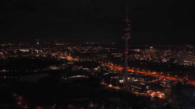 Drohnenvideo vom Fernsehturm im Muenchner Olympiapark. Einzigartige Aussicht auf das Stadtpanorama und die festliche Beleuchtung in Deutschland zur Neujahrsnacht im Winter