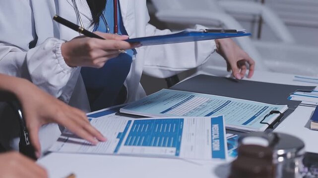 Group of diverse doctors and medical team analyzing digital x-ray scan on tablet during meeting in hospital clinic.