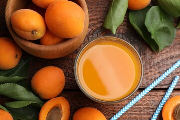 Apricot juice in glass, fresh fruits and drinking straws on wooden table, flat lay © New Africa