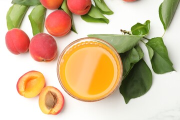 Glass of apricot juice, fresh fruits and leaves on white table, flat lay © New Africa