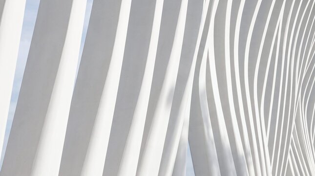Abstract architectural white columns creating dynamic wavy patterns against a clear bright blue sky