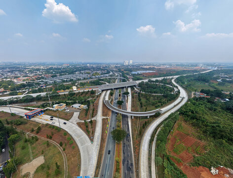 Aerial view of BSD Main Toll Gate and highway interchange with surrounding greenery and urban development in Kecamatan Pagedangan, Banten, Indonesia.
