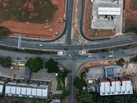 Aerial view of The Icon BSD City intersection with vehicles navigating the roads, surrounded by modern residential buildings, construction sites, and lush greenery in Tangerang, Banten, Indonesia.