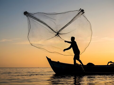 Fisherman casting a net from a boat during golden sunset