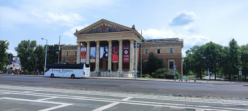 Budapest, Hungary - 26 June 2024, A tour bus is seen parked outside a historical building in Budapest. People walk nearby