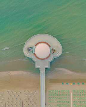 Aerial view of Rotonda a Mare extending into the Adriatic Sea with sandy beaches and rows of umbrellas in Senigallia, Marche, Italy.