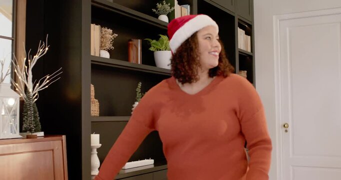 African American woman entering from right wearing Santa hat moving to piano and playing carol