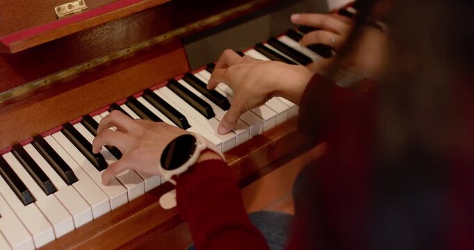 African American female duo practicing at piano, starting with hands on keys, smartwatch and ring