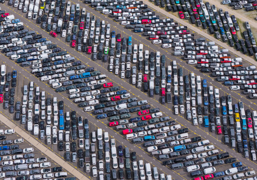 Aerial view of a large vehicle transport and storage facility with rows of cars parked in diagonal lines in Poznan, Greater Poland Voivod, Poland.