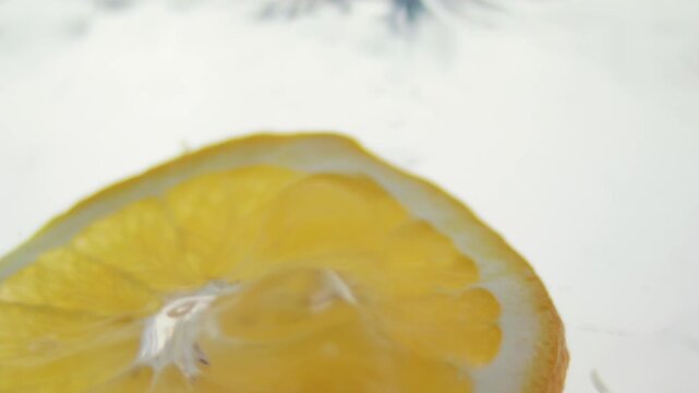 Macro close up of a slice of Orange  splashing in water in slow motion