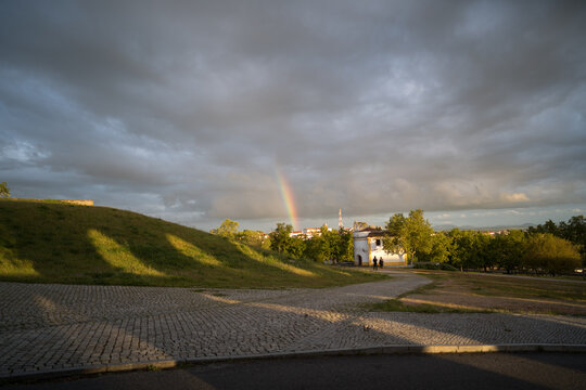 Rainbow Over Elvas Portugal with Cobblestone Paths and Green Hill