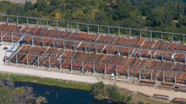Aerial view of the British Steel storage facility with rows of stacked steel beams and industrial metal structures situated near a water body in Scunthorpe, England, United Kingdom.