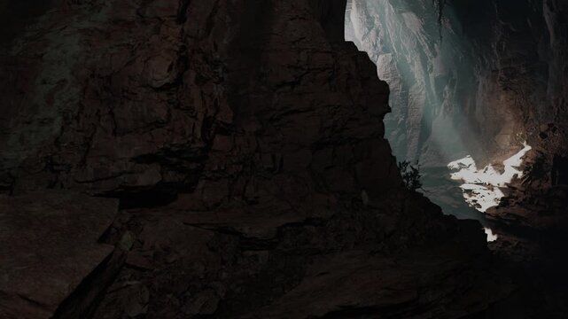 Light enters a cave through a narrow opening. Shadows cover the rocky walls while the ground has some plants growing. The scene captures a moment of nature and geology.