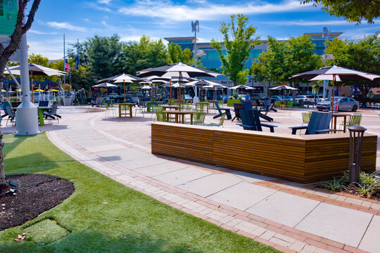 Outdoor tables and umbrellas fill One Loudoun plaza in Ashburn, Virginia.