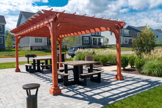 Outdoor seating beneath a wooden pergola overlooks modern homes in Leesburg, Virginia.