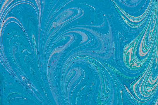 Dynamic abstract liquid background with swirling blue, cyan, and white paint marble textures.