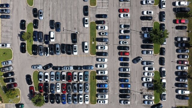 Aerial view of a busy parking lot filled with various cars parked in organized rows, showing asphalt surfaces and green landscaping in Brentwood, Tennessee, United States.