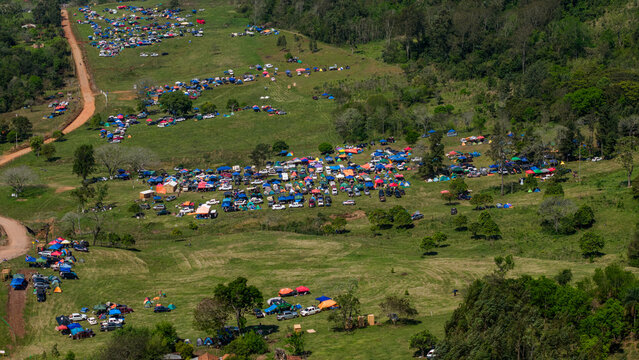Aerial view of Rally Paraguay 2026 campsite with numerous colorful tents and vehicles scattered across a grassy hillside in Nueva Alborada, Itapua Department, Paraguay.