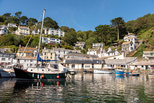 Polperro Cornwall England UK. 13.08.2026. Polperro a charming coastal village with traditional houses nestled on a hillside overlooking a tranquil harbour filled with various boats