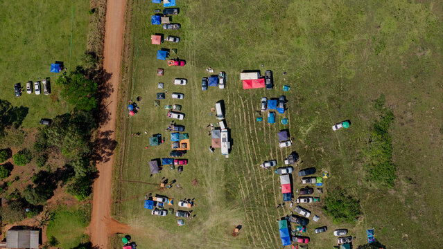 Aerial view of Rally Paraguay 2026 spectator area with parked cars and tents in a grassy field in Nueva Alborada, Itapua Department, Paraguay.