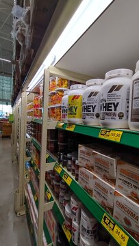 ITABIRA, BRAZIL - AUGUST 26, 2026: Retail display of whey protein bars and fitness supplements in a supermarket aisle with price tags and barcodes