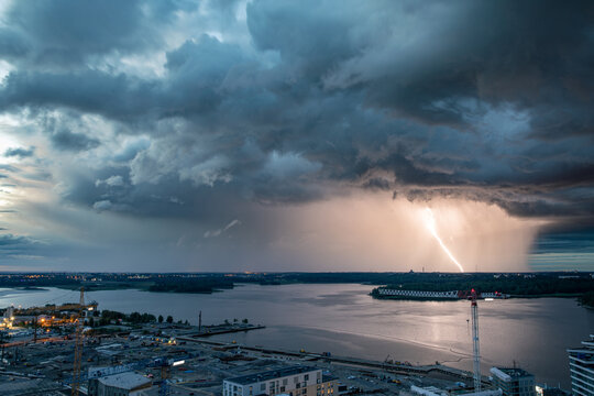 Aerial view of a dramatic lightning strike illuminating dark storm clouds over the sea near Kalasatama construction sites in Helsinki, Uusimaa, Finland.
