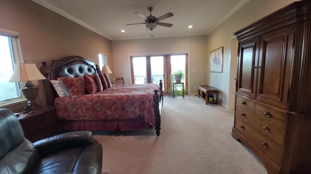 Cozy bedroom with four poster bed tufted headboard daylight streaming through balcony doors onto