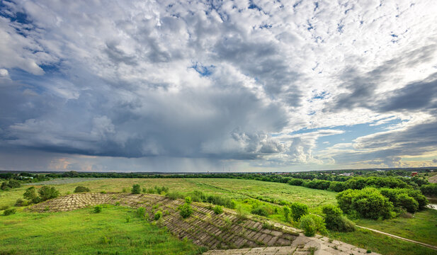 Breathtaking sweeping green fields roll endlessly beneath a moody