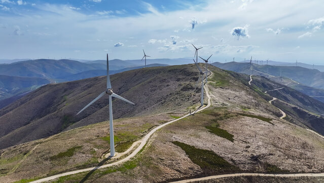 Aerial view of a wind farm with multiple wind turbines across a mountainous landscape, representing renewable energy and clean power in Lisbon, Lisbon, Portugal.