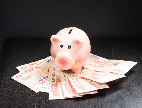 pink piggy bank for saving money on a light background
