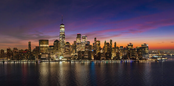 UNITED STATES, NEW YORK CITY. AERIAL VIEW OF LOWER MANHATTAN SKYLINE AT SUNRISE WITH WORLD TRADE CENTER AND FINANCIAL DISTRICT SKYSCRAPERS