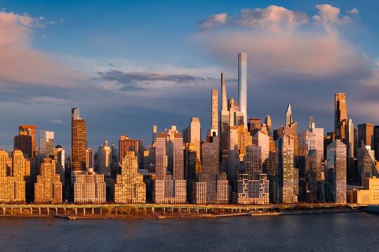 UNITED STATES, NEW YORK CITY, MANHATTAN. AERIAL VIEW OF THE CITY SKYLINE AT SUNSET ALONG THE HUDSON RIVER WITH MIDTOWN WEST AND BILLIONAIRES? ROW SUPERTALL SKYSCRAPERS