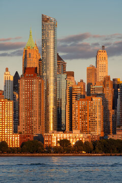 UNITED STATES, NEW YORK CITY, MANHATTAN. SUNSET LIGHT ON BATTERY PARK AND LOWER MANHATTAN SKYSCRAPERS IN NEW YORK CITY. CITYSCAPE FROM THE HUDSON RIVER