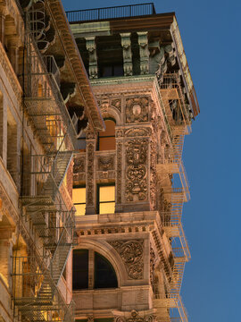 UNITED STATES, NEW YORK CITY. SOHO BUILDING WITH INTRICATE FACADE, TERRA COTTA ORNAMENTATION, COPPER CORNICE AND PAINTED IRON FIRE ESCAPE
