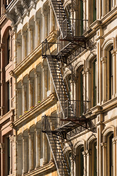 UNITED STATES, NEW YORK CITY, MANHATTAN, SOHO. TYPICAL SOHO BUILDING FACADES WITH FIRE ESCAPES LOCATED IN THE SOHO CAST IRON BUILDING HISTORIC DISTRICT