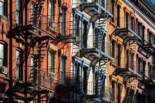 UNITED STATES, NEW YORK CITY, MANHATTAN, SOHO. COLORFUL SOHO BUILDING FACADES WITH PAINTED FIRE ESCAPES
